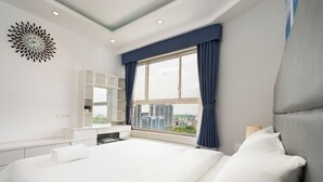 Una habitación de hotel moderna con una cama grande, un escritorio integrado, vista a la ciudad por la ventana y un reloj de pared decorativo.
