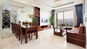 Una sala de estar moderna con comedor, sofá, televisión y balcón con vistas.