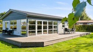 A modern house with a large glass extension, a wooden deck, and a well-maintained lawn. - "Todor" - 150m from the sea by Interhome (Nordborg)