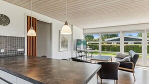 A modern kitchen with a large island, pendant lighting, and a view of the outdoors. - "Todor" - 150m from the sea by Interhome (Nordborg)