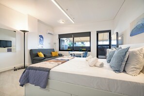A modern bedroom with a large bed, a desk, and a sofa. - Stylish studio for 2 in Abelokipi (Athina)