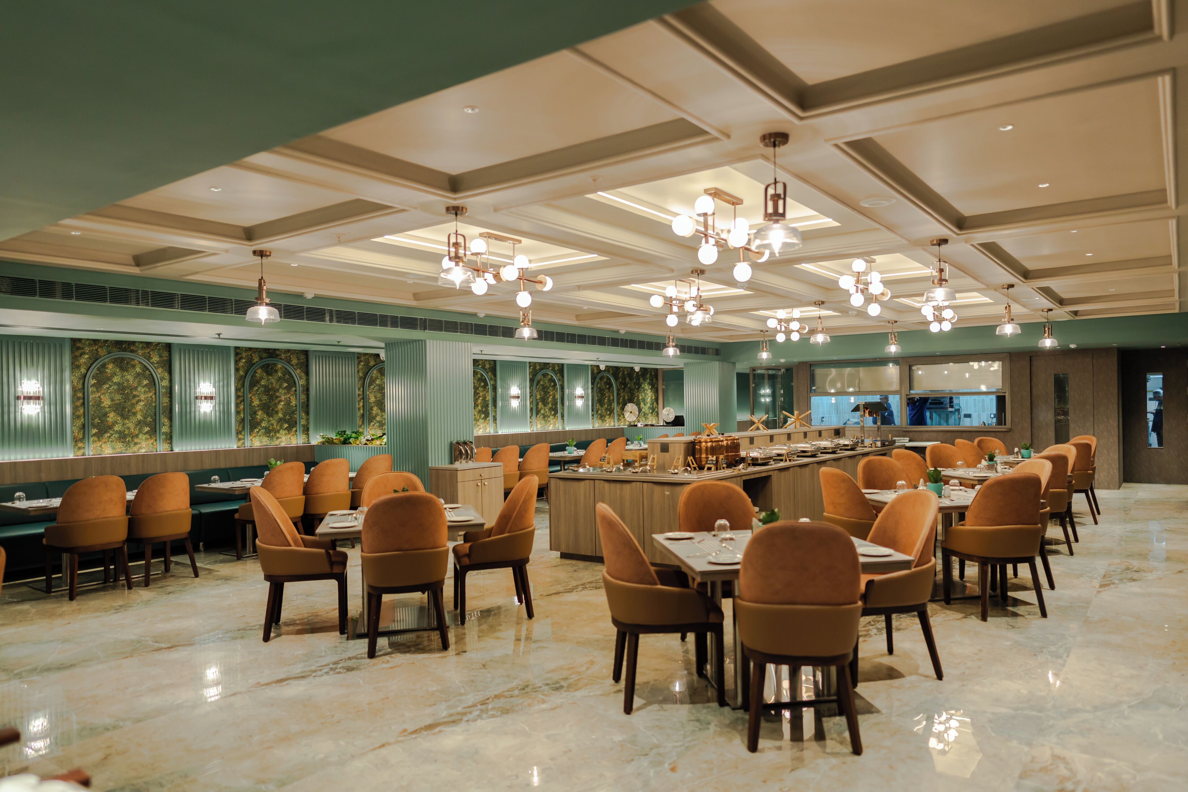 A spacious restaurant with a long counter, multiple tables, and chairs.