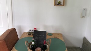 Ein Holztisch mit grüner Tischmatte, einem Flaschenkorb und einem Kreidetafel-Schild.