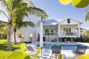 A modern house with a swimming pool, outdoor seating, and palm trees. - Floralee House in Key West (Key West)