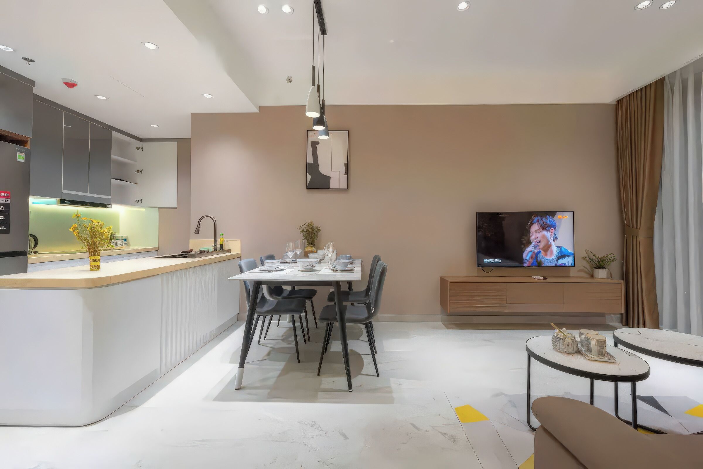 A modern living room with a dining area, a kitchen, and a TV.