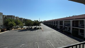 Un estacionamiento con una hilera de edificios tipo motel.