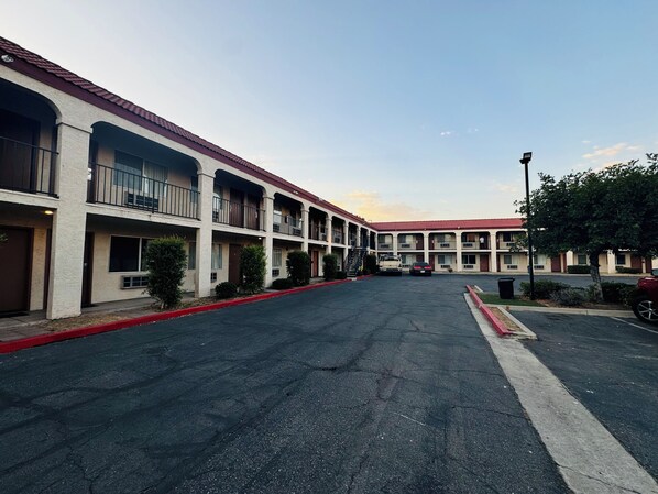 A motel with multiple balconies, a parking lot, and a red curb. - Casa Blanca Hotel - Azusa, Los Angeles (Azusa)