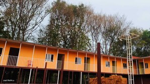 A multi-story building with balconies and a central staircase. - Divya Prayag Kumbh Camp  (Karchana)