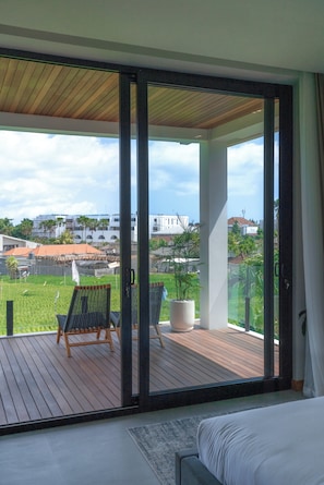 Ein Balkon mit Holzboden, einem Blumentopf und einem Stuhl.