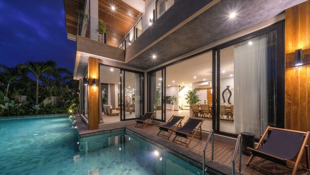 A modern house with a swimming pool, lounge chairs, and a dining area. - Villa Amaluna (Canggu)