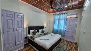 A bedroom with a bed, wardrobe, and a ceiling fan. - For Rest Home Shimla  (Shimla)