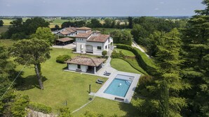 Un vaste domaine comprenant plusieurs bâtiments, une piscine et de beaux jardins bien entretenus.