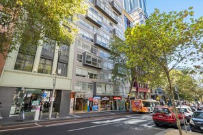 Un edificio de varios pisos con locales comerciales en la planta baja, incluyendo un restaurante y un bar.