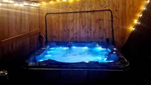 Een hottub met een houten binnenkant en lichtjes.