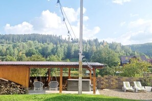 A wooden building with a covered patio, outdoor seating, and a hot tub. - Bucovina-mountainhouse-5br-fireplace-hottub-wifi (Sucevita)