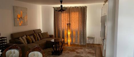 Una sala de estar con sofá, sillas, una mesa y una lámpara de pie.