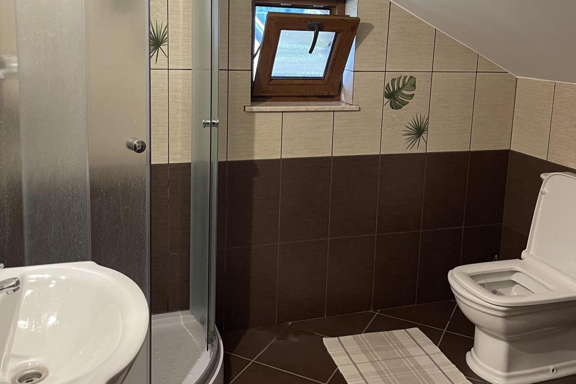 A bathroom with a shower, a toilet, and a sink.