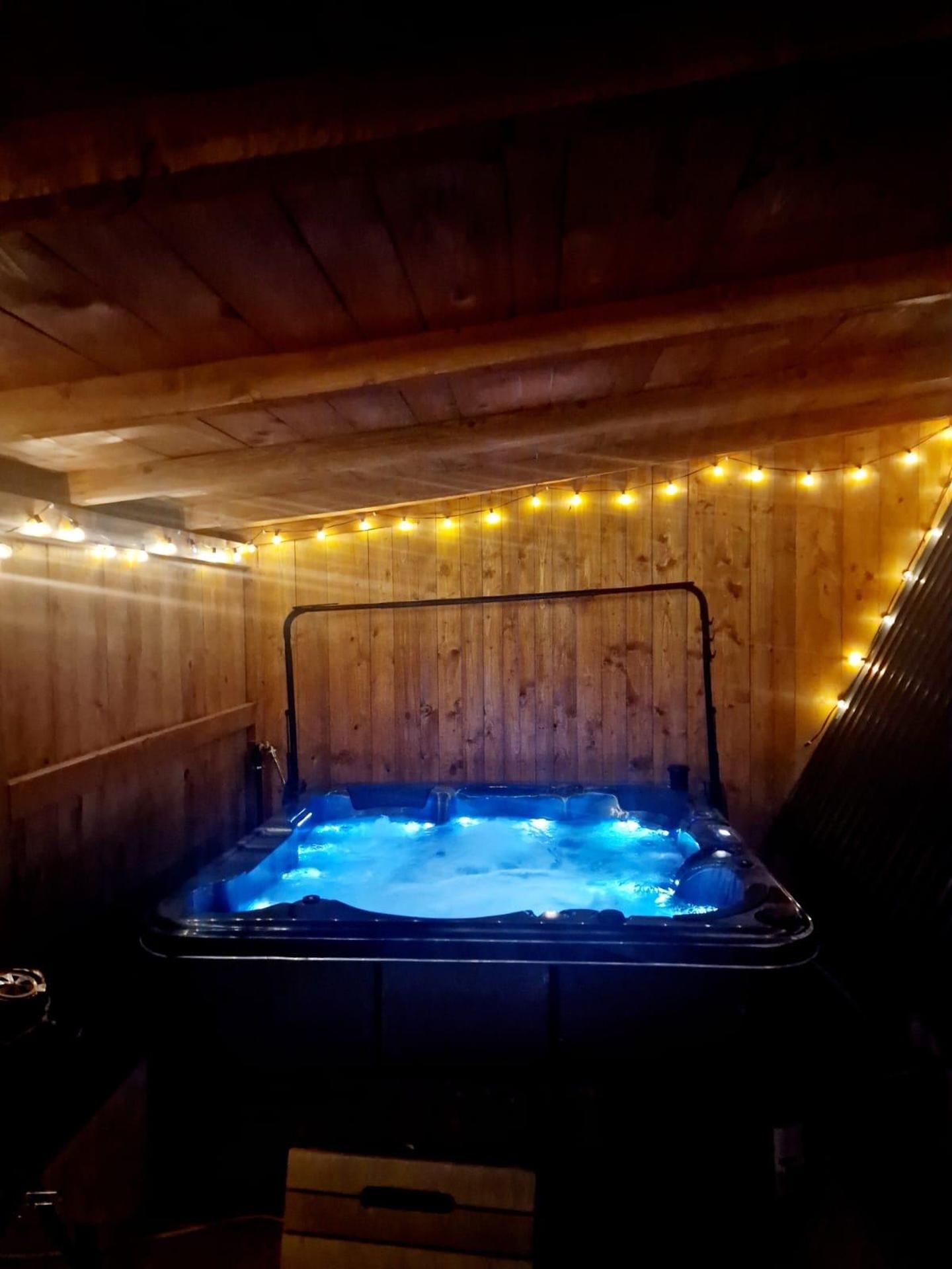 Ein Whirlpool mit Holzvertäfelung und Lichterketten.