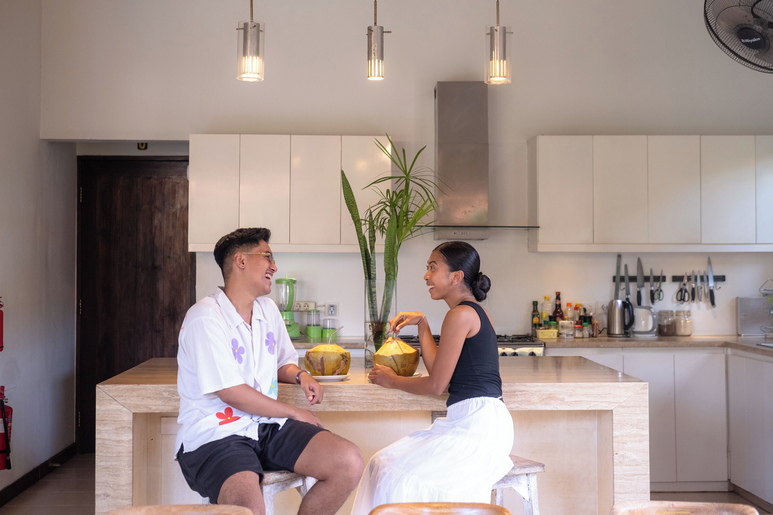 A modern kitchen with white cabinets, a central island, and pendant lighting.