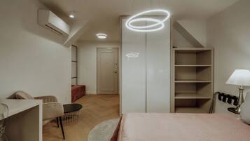 Un dormitorio moderno con cama, mesita de noche, lámpara y armario.