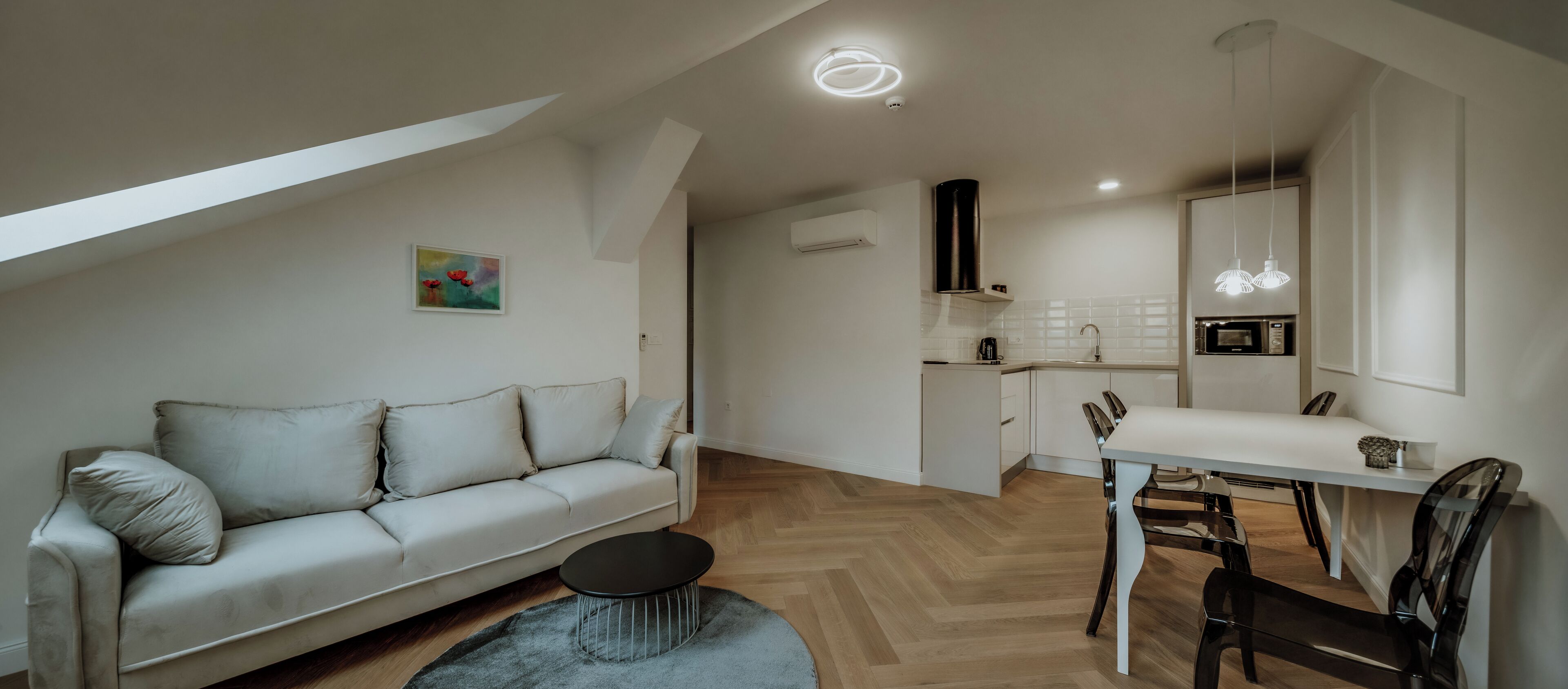 A modern apartment with a living area, kitchenette, and dining space.