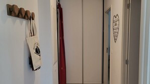 A hallway with a wooden floor, a white door, and a red curtain.