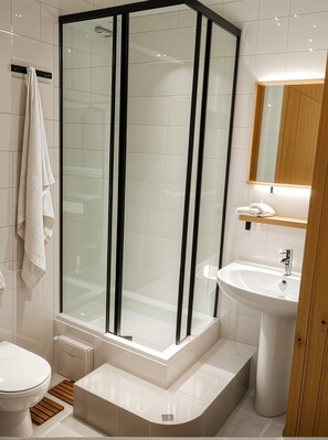 A modern bathroom with a glass-enclosed shower, a white sink, and a toilet. - cinecittaroomshaven (Rome)