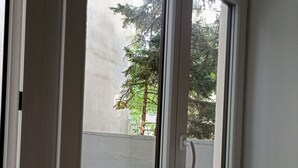 A window with a view of a tree and a wall. - 170m2 with private garden (Wien)