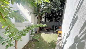 A small backyard with a tree, a grassy area, and a wooden bench. - 170m2 with private garden (Wien)