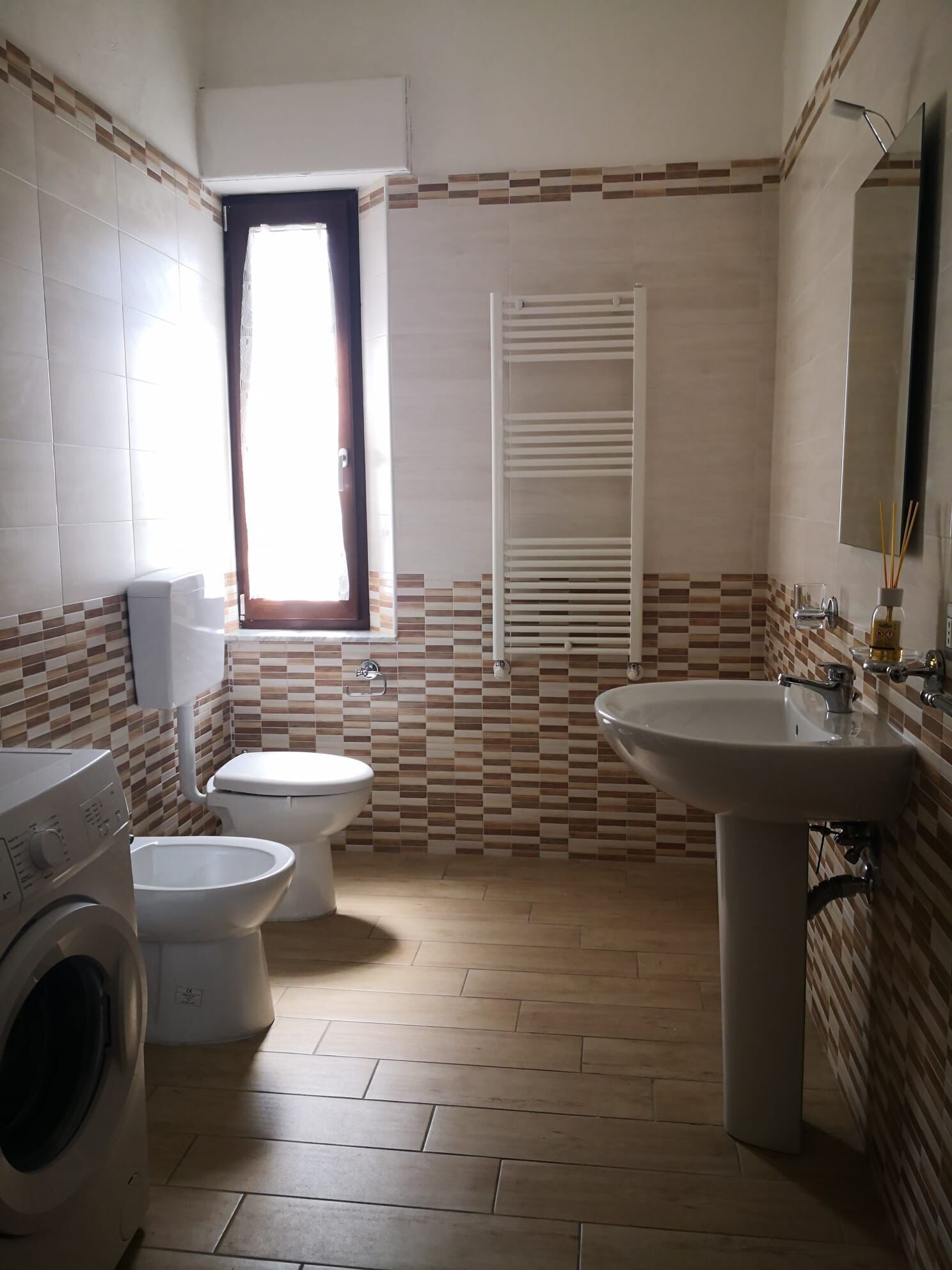 Ein Badezimmer mit Waschmaschine, Toilette und Waschbecken.