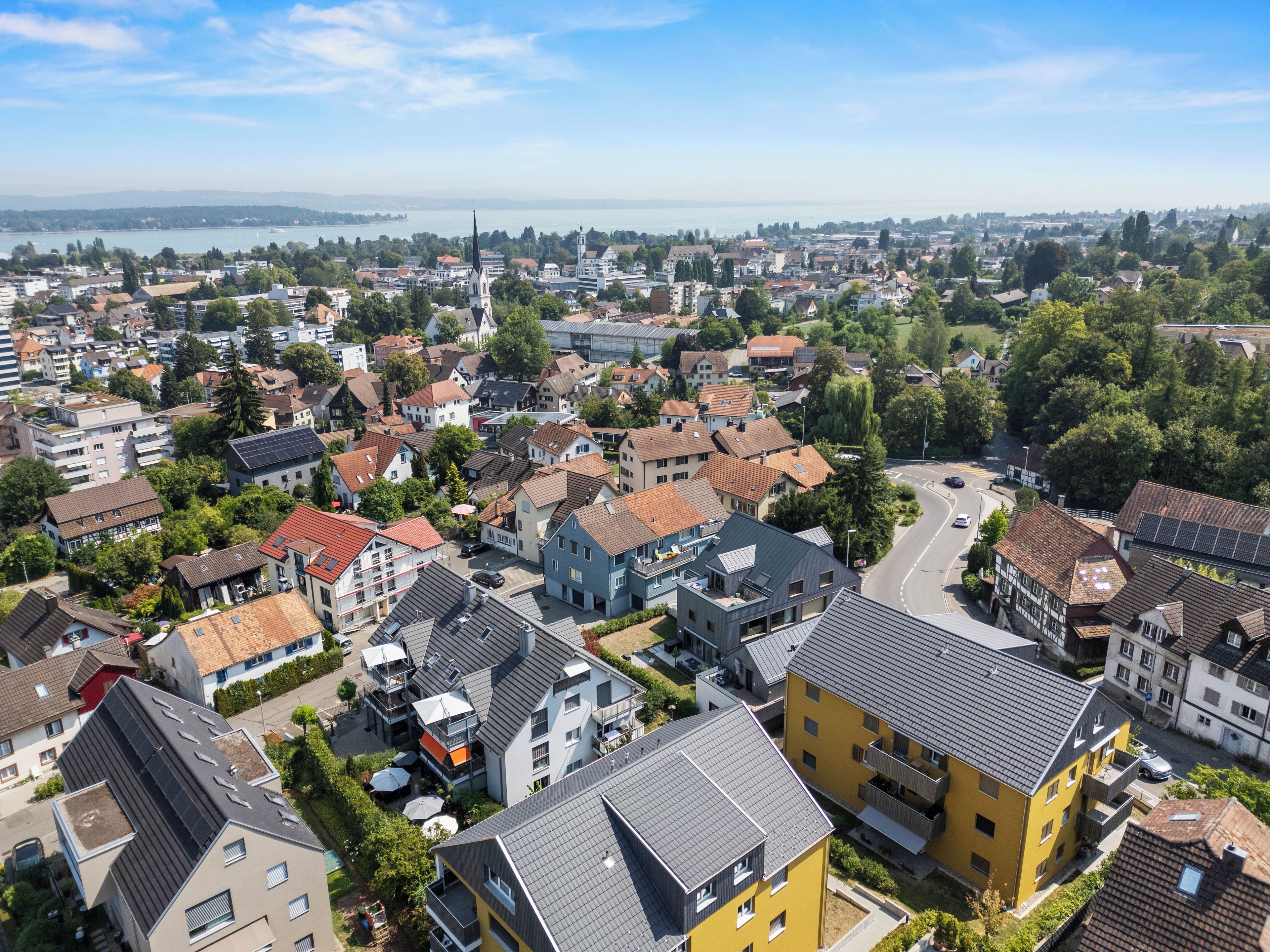 A residential area with a variety of building styles, including modern and traditional houses, and a clear view of the surrounding landscape.