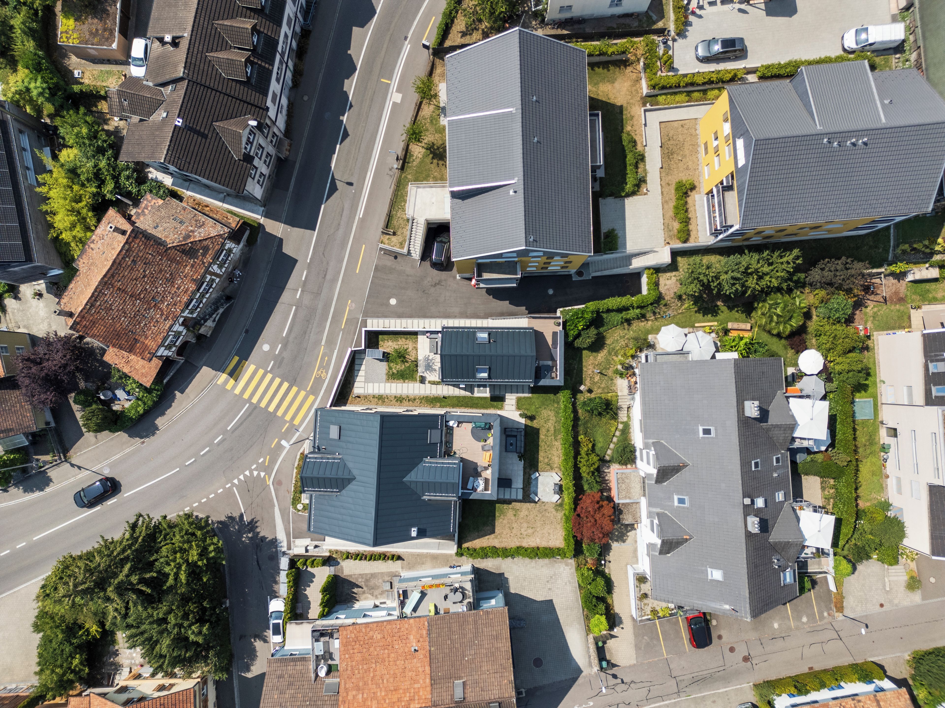 Vista aérea de una zona residencial con casas, una calle y un estacionamiento.