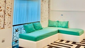 Una habitación moderna con un sofá modular, una pared estampada y una lámpara colgante grande.