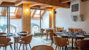 Un comedor con vigas de madera, ventanas amplias y mobiliario moderno.