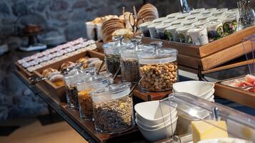A buffet with various food items and containers, including jars of nuts and seeds, and a selection of pastries.