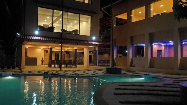 A modern two-story building with a swimming pool and outdoor seating area. - Amansaraa Bhide Retreat (Alibag)