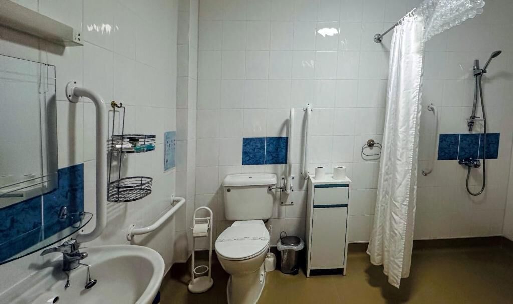 A bathroom with a toilet, sink, and shower.