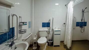 A bathroom with a toilet, sink, and shower.