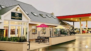 Hotel Ocean Haze met een overdekte buiten zitplaats en een benzinestation op de achtergrond.