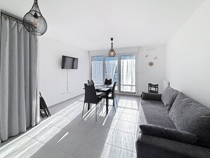 Relax in this stylish living space with a dining area, comfortable sofa, and flat-screen TV.