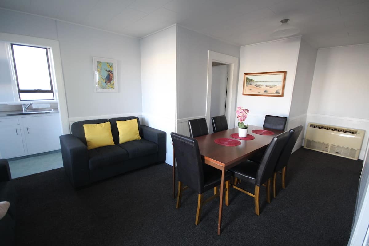 A compact living space with a dining area, a kitchenette, and a small bathroom.