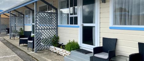 Un motel con un porche cubierto, mobiliario exterior y el número 5 pintado en el pavimento.