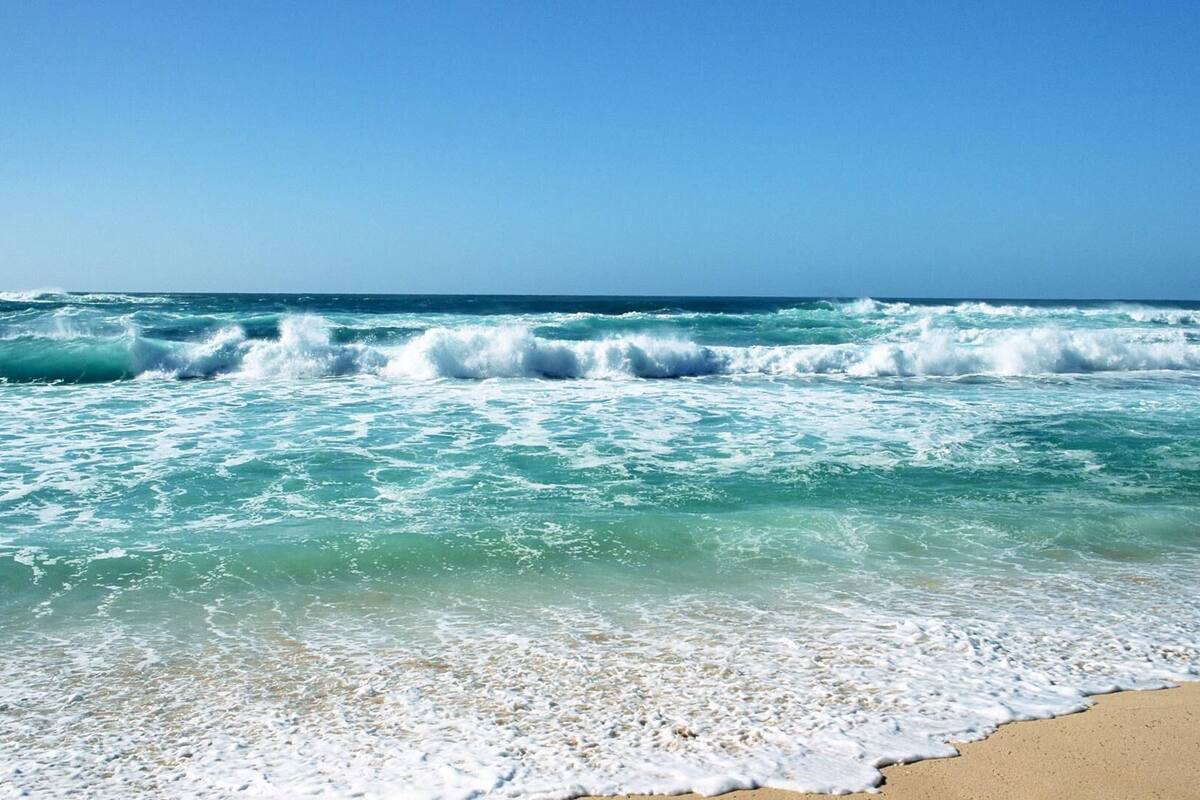 A beach with waves crashing onto the shore.