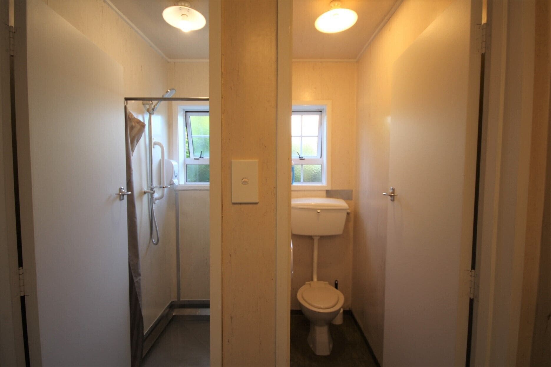 Kapea käytävä johtaa kylpyhuoneeseen, jossa on wc, suihku ja ikkuna.