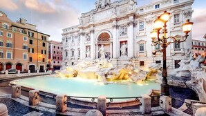 A historic fountain with sculptures, surrounded by classical architecture and a street view. - Rhome Luxury suite (Rome)