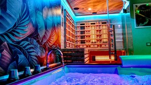 Un espace spa agrémenté d’une grande fresque murale, d’un plafond en bois et d’un coin salon offrant une vue sur le spa.