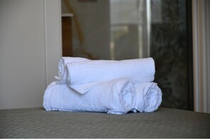 A stack of white towels on a textured surface, likely in a hotel room. - DIMORA IL TARTUFO (Busso)