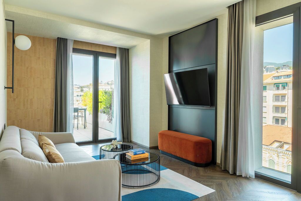 Una sala de estar moderna con un sofá, una mesa de centro y un televisor de pantalla plana montado en la pared.