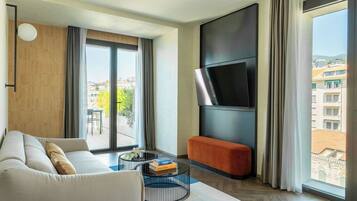 Una sala de estar moderna con un sofá, una mesa de centro y un televisor de pantalla plana montado en la pared.