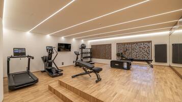 A modern home gym with treadmills, a bench press, and a rowing machine.